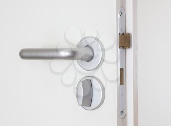 White door with chrome doorhandle, selective focus