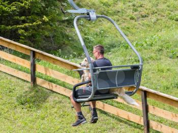 Ski lift chair in the Alps - Unrecognisable man with a dog - Austria