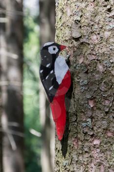 Education in the forest - wooden woodpecker waiting to be spotted by children - Selective focus