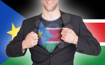 Businessman opening suit to reveal shirt with flag, South Sudan