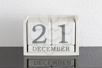 White block calendar present date 21 and month December on white wall background