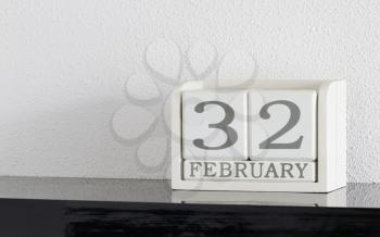White block calendar present date 32 and month February on white wall background - Extra day