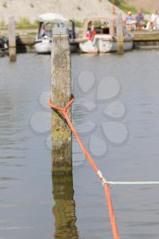 Nautical rope tied around a post on the pier