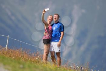 Nauders, Austria- August 5, 2017 : Couple taking picture of them by using smart phone in the mountains at Nauders, Austria
