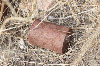 Garbage in nature - A rusty can on a field
