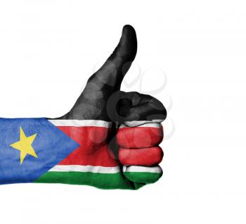Closeup of male hand showing thumbs up sign, flag of South Sudan