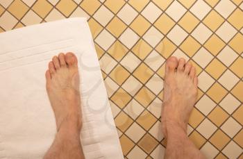 After taking a shower; Male feet on a vintage bathroom floor, selective focus