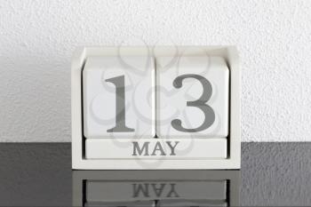 White block calendar present date 13 and month May on white wall background