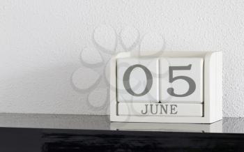 White block calendar present date 5 and month June on white wall background