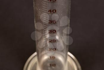 Old measuring cylinder, isolated on black, selective focus