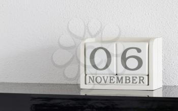 White block calendar present date 6 and month November on white wall background