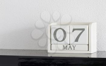 White block calendar present date 7 and month May on white wall background