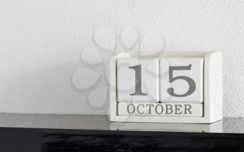 White block calendar present date 15 and month October on white wall background