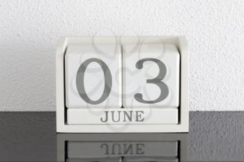 White block calendar present date 3 and month June on white wall background