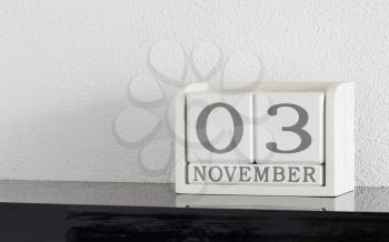 White block calendar present date 3 and month November on white wall background