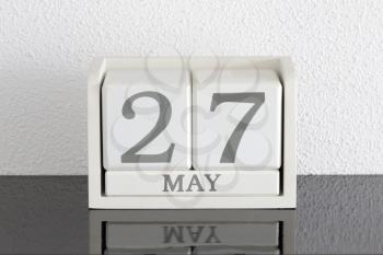 White block calendar present date 27 and month May on white wall background