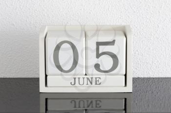 White block calendar present date 5 and month June on white wall background