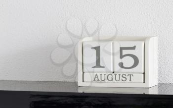 White block calendar present date 15 and month August on white wall background