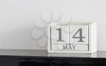 White block calendar present date 14 and month May on white wall background