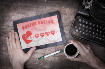 Online dating on a tablet - concept of love, red pacman eating hearts
