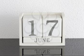 White block calendar present date 17 and month June on white wall background