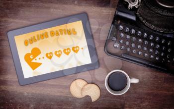 Online dating on a tablet - concept of love, yellow pacman eating hearts
