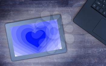 Heart shape backgound on a tablet - Concept of love - blue