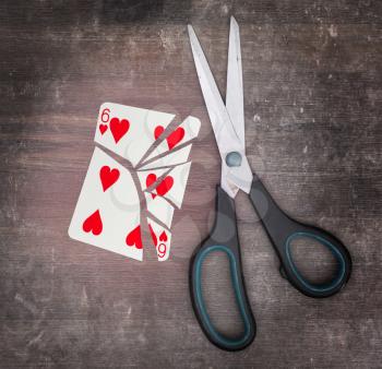 Concept of addiction, card with scissors, six of hearts