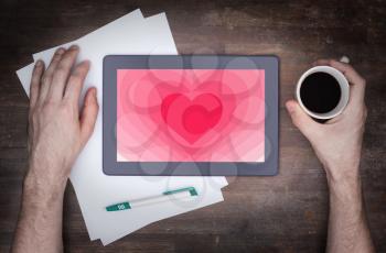 Heart shape backgound on a tablet - Concept of love - pink