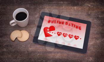 Online dating on a tablet - concept of love, red pacman eating hearts