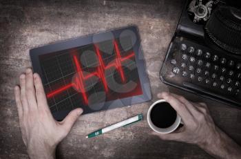 Electrocardiogram on a tablet - Concept of healthcare, heartbeat shown on monitor - red