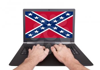 Man working on laptop, confederate flag, isolated