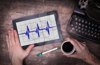 Electrocardiogram on a tablet - Concept of healthcare, heartbeat shown on monitor - blue
