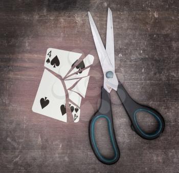Concept of addiction, card with scissors, four of spades