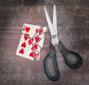Concept of addiction, card with scissors, nine of hearts