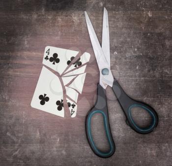 Concept of addiction, card with scissors, four of clubs