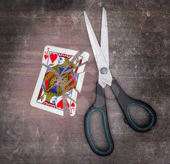 Concept of addiction, card with scissors, jack of hearts