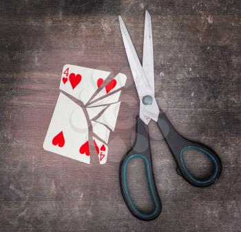 Concept of addiction, card with scissors, four of hearts