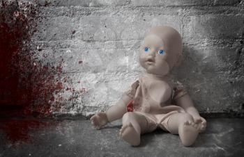 Concept of child abuse - Bloody doll, vintage