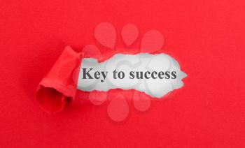 Text appearing behind torn red envelop - Key to success