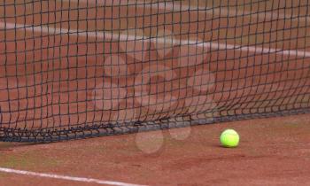 Tennis ball on the orange tenniscourt, selective focus