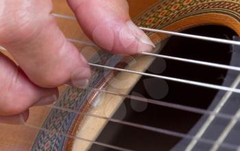 Close up on an old woman's hand playing guitar