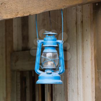 Old blue lantern in a wooden shed