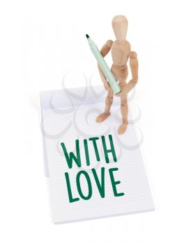 Wooden mannequin writing in a scrapbook - With love