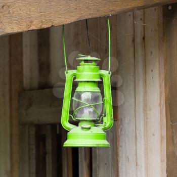 Old green lantern in a wooden shed