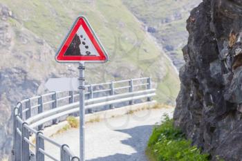 Warning stone fall road sign on mountain road, Switzerland
