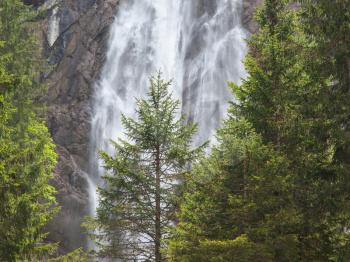 Waterfall in the forest, raging water in Switzerland