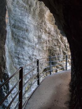Cave in Switzerland, dark and wet footpath, selective focus