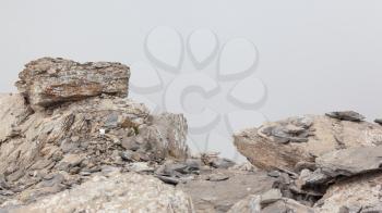 Large boulders in fog on a Swiss mountain summit