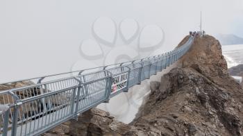LES DIABLERETS, SWIZTERLAND - JULY 22: People walk at the Glacier 3000 on July 22, 2015. The area houses the world only suspension bridge between 2 mountain peaks.